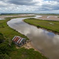 Aerial View of a Rustic House by a Meandering River Royalty Free Stock Photo