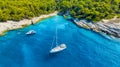 Aerial view on sail yacht, rocks and forest. Sea coastline. Vacation and adventure. Rocks and turquoise water. Royalty Free Stock Photo