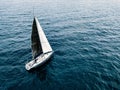 Aerial view of sailing ship yacht with white and black sails at deep open sea Royalty Free Stock Photo