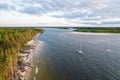 Aerial view of sailing white yacht in sea next to pine forest Royalty Free Stock Photo