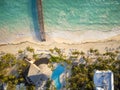 Aerial view of a sandy beach with palm trees, small houses. Clear warm sea and a wooden bridge. Resort town, infrastructure, map, Royalty Free Stock Photo