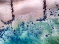 Aerial view of sandy beach with waves, clear ocean water and big black stones. It is tropical paradise in Senegal, Africa. It is Royalty Free Stock Photo