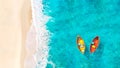 Aerial View of Sandy Tropical Beach and Ocean with Two Yellow and Red Boats Floating on Turquoise Water Royalty Free Stock Photo