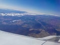 Aerial view scene from the left wingside of aeroplane flying in sunny day with blue sky Royalty Free Stock Photo