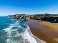 Aerial view of sea waves breaking sandy beach with greenery cliffs Royalty Free Stock Photo