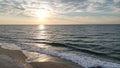 Aerial view of sea waves breaking sandy beach during sunset Royalty Free Stock Photo