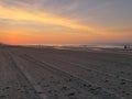 Aerial view of sea waves breaking sandy beach during sunset Royalty Free Stock Photo