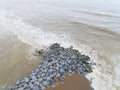 Aerial view of sea waves hitting rocks on the beach in Pantai cahaya bulan