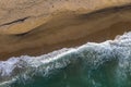 Aerial view of sea waves and a remote secluded sandy beach