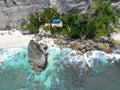 Aerial view of the sea waves splashing over the sea stacks in Denpasar, Bali, Indonesia