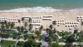 Aerial view of sea waves, umbrellas, green palms on the sandy beach. Tropical landscape. Top view from air. Nha trang Royalty Free Stock Photo