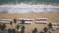 Aerial view of sea waves, umbrellas, green palms on the sandy beach. Tropical landscape. Top view from air. Nha trang Royalty Free Stock Photo