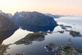 Aerial view of the serene Reine village in Lofoten, Norway under the midnight sun, with mountain reflections on calm waters Royalty Free Stock Photo