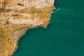 Aerial view of a shore area of a lake where sand and birds such as ducks cavort