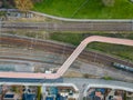 Aerial view shot by a drone of a cyclists and pedestrian bridge over the railroad tracks Royalty Free Stock Photo