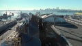 An aerial view of silos in the North Vancouver cargo terminal and trainyard with a view of downtown Vancouver.