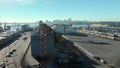 An aerial view of silos in the North Vancouver cargo terminal and trainyard with a view of downtown Vancouver.