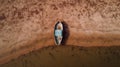 Aerial view of a single fishing boat on the dry surface of a drought lake bed, top view Royalty Free Stock Photo