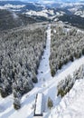 Aerial view of ski lift in resort Pamporovo, Bulgaria. Winter landscape with snow covered fir trees and mountain range Royalty Free Stock Photo