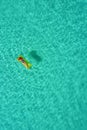 Aerial view of slim woman swimming on the swim mattress in the t