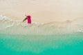 Aerial view of slim woman swimming on the swim mattress in the transparent turquoise sea. Summer seascape with girl, beautiful