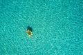 Aerial view of slim woman swimming on the swim ring donut in the transparent turquoise sea in Seychelles. Summer seascape with Royalty Free Stock Photo