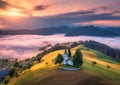 Aerial view of small church on the hill over pink low clouds Royalty Free Stock Photo