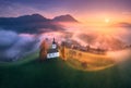 Aerial view of small church on the hill over pink low clouds Royalty Free Stock Photo