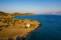 Aerial view of a small church next to a blue ocean on a hot Greek island Royalty Free Stock Photo