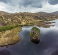 An aerial view of a small forested island and the northern shore of Loch Eilt, Scotland