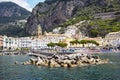 Aerial view of small haven of Amalfi village with turquoise sea and colorful houses on slopes of Amalfi Coast with Gulf of Salerno