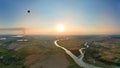 Aerial view of small hot air baloon flying over rural countryside at sunset Royalty Free Stock Photo