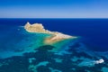 Aerial view of a small island and boats in a crystal clear blue ocean Royalty Free Stock Photo