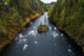 An aerial view of a island in river rapids flowing through lush Finnish taiga forest Royalty Free Stock Photo