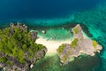 Aerial view of small isolated tropical island with white sandy beach and blue transparent water and coral reefs Royalty Free Stock Photo