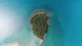 AERIAL view of small isolated tropical island with white sandy beach and blue transparent water and coral reefs. Top Royalty Free Stock Photo