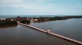 Aerial view of small long bridge crossing river to island. a shelter on walking bridge. lonely pavilion Royalty Free Stock Photo