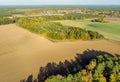 Aerial view of a small piece of forest between fields and meadows behind a village in northern Germany