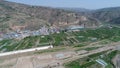 Aerial view of small poor town next the arid terraced farm firld mountain