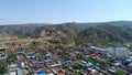 Aerial view of small poor town next the arid terraced farm firld mountain