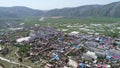 Aerial view of small poor town next the arid terraced farm firld mountain