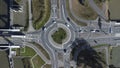 Aerial view of a small roundabout at the intersection of two asphalted gray country roads
