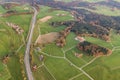 Aerial view of small scattered farm houses with red tiled roofs among green farming fields and distant forest in summer Royalty Free Stock Photo