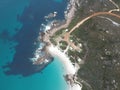 Aerial view of small shacks by the beach and rocks