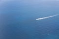 Aerial view of a small ship navigating at a blue ocean