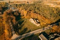 Aerial view small town in autumn landscape. Bird's-eye view of ruins of the brewery, neo-gothic monument of