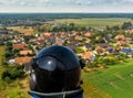 Aerial view of a small village in the distance behind a piece of forest and an asparagus field covered with foil, made with drone.