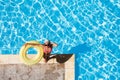 Happy woman standing at poolside with rubber ring Royalty Free Stock Photo