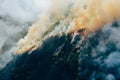 Aerial view smoke clouds of wild fire. Fire in forest spreads, natural disaster. Dry grass and trees burning. Climate