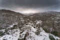 Aerial view of snow-capped mountains and leafless trees in La Hiruela, Madrid, Spain